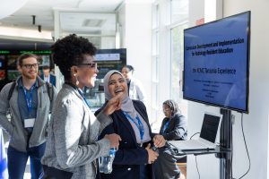 Arlene + presenter with slide doing poster Lobby